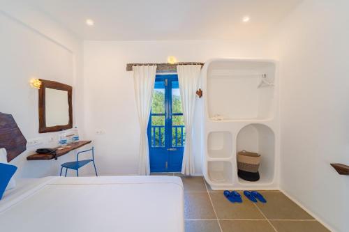 a bedroom with a bed and a blue door at Conch Resort Luxury Private Pool Suites in Puducherry