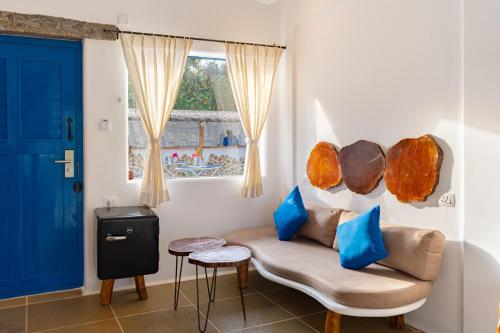 a living room with a couch and a blue door at Conch Resort Luxury Private Pool Suites in Puducherry