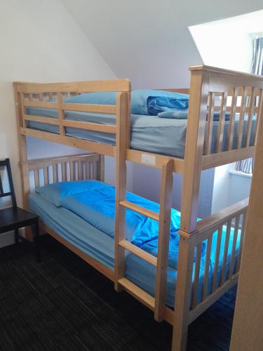 a bunk bed room with two bunk beds with blue sheets at Torrin Bunkhouse in Torrin