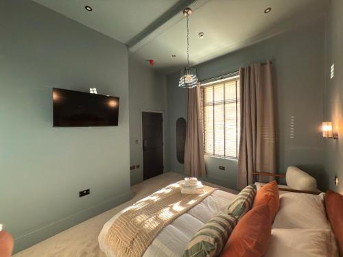 a bedroom with a bed and a television on the wall at Akroyd House - The Mackintosh Room in Halifax