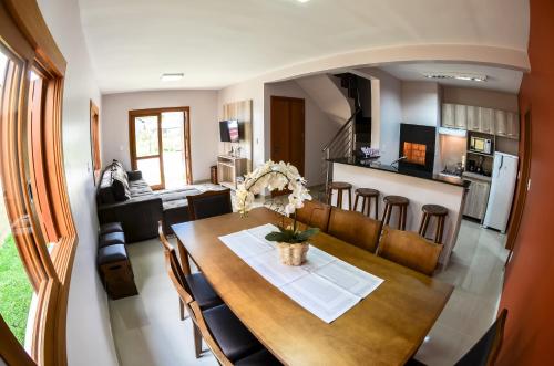 a dining room and kitchen with a table and chairs at Casas dos Alpes in Gramado