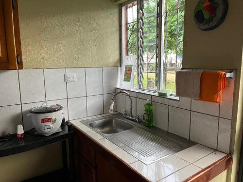 a kitchen with a sink and a window at La Casa del Viajero in Puerto Viejo