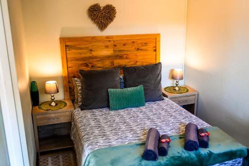 a bedroom with a bed with two lamps and two beds at Old Roastery Cottage in Bloemfontein