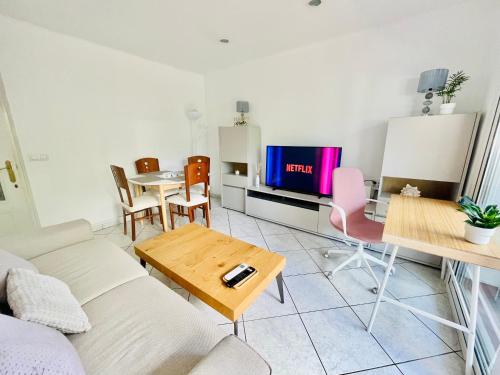 a living room with a couch and a table and a tv at Hauzify I Apartament Gaviota in S'Agaro