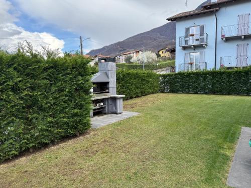 a garden with a stone grill in front of a house at Agata House in Colico