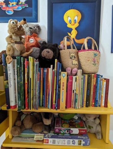 a shelf filled with books and stuffed animals at Piecówka Wysokie Kaczki in Kaczkowo