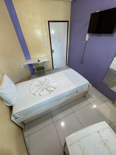 une petite chambre avec un lit et un miroir dans l'établissement Comodoro Hotel e Churrascaria, à Floriano