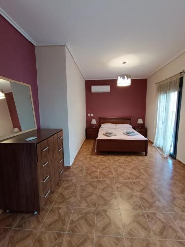 a large room with a bed and a mirror at Komi Luxury Maisonette in Kómi