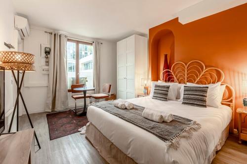 a bedroom with a large bed with an orange wall at 41#Opéra #GrandsBoulevards #Studio # Paris 02 #AC in Paris