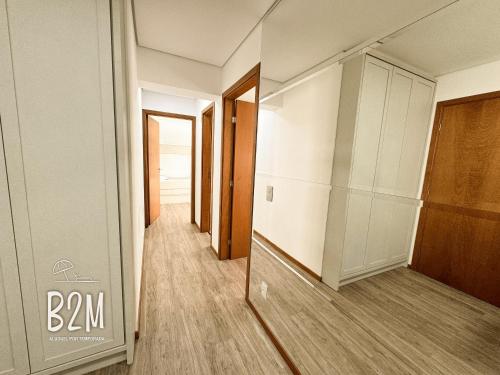 a hallway with a glass door and a hallway with a closet at Beto Carrero, pé na areia, piscina aquecida, Bali in Piçarras
