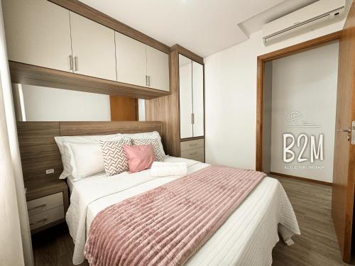 a bedroom with a large bed with a pink pillow at Beto Carrero, pé na areia, piscina aquecida, Bali in Piçarras