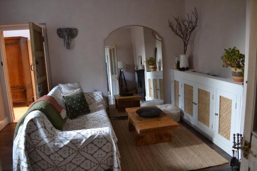 a living room with a couch and a table at Chapel Cottage- Coastal Somerset Retreat in Williton