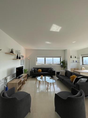 a large living room with couches and a table in it at 2 Bedroom Apartment AYA tower Mar Mikhael - Beirut in Beirut