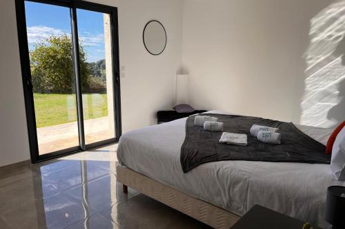 une chambre avec un grand lit et une grande fenêtre dans l'établissement Romane - Terrace Garden Great View - by TGB, à Alata