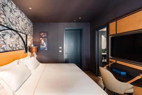 a bedroom with a bed and a flat screen tv at The Goethe Hotel - Small Luxury Hotels of the World in Rome