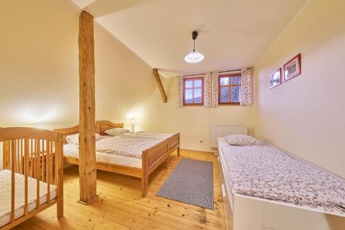 a bedroom with two beds and a crib at Horská chalupa U Hančilů in Pec pod Sněžkou