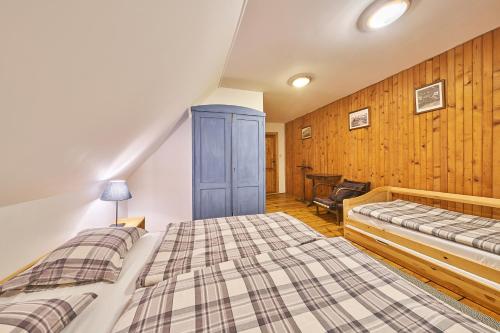 a bedroom with two beds and a chair in it at Horská chalupa U Hančilů in Pec pod Sněžkou