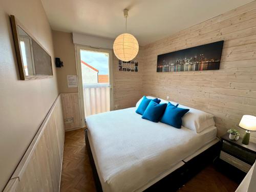 une chambre avec un grand lit avec des oreillers bleus dans l'établissement BleuBlancMer, à Wissant