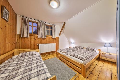 a bedroom with two beds and a window at Horská chalupa U Hančilů in Pec pod Sněžkou