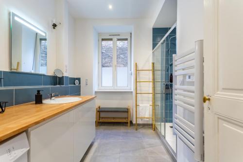 une salle de bain avec un lavabo et un miroir dans l'établissement L'Élégant - Charmant appartement 3 pièces proche Musée d'Art Moderne et Gare Centrale, à Strasbourg