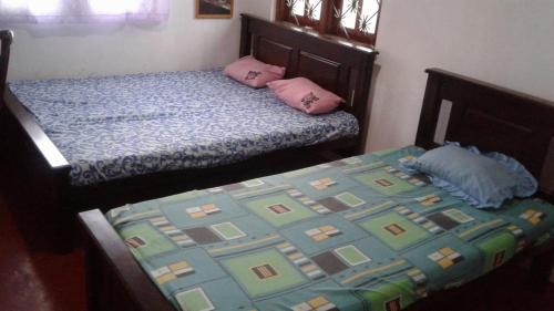 a bedroom with two beds with pink pillows at Rajawasala rooms resport & spa in Hambantota
