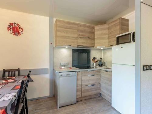 une cuisine avec des armoires en bois et un réfrigérateur blanc dans l'établissement Charmant appartement rénové pour 6 avec balcon et casier à ski à Plagne Bellecôte - FR-1-351-108, à Plagne Bellecôte