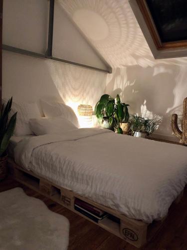 - une chambre dotée d'un lit blanc avec des plantes dans l'établissement Charmant petit duplex, à Montpellier