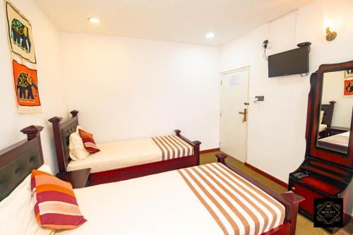 a small room with two beds and a mirror at Hotel Mount Castle in Hatton