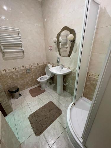 a bathroom with a toilet and a sink and a shower at Sava Dream in Zhytomyr
