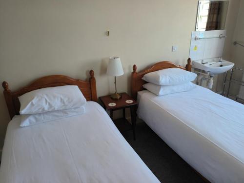 two beds sitting next to each other in a room at Royal Norfolk & Suffolk Yacht Club in Lowestoft