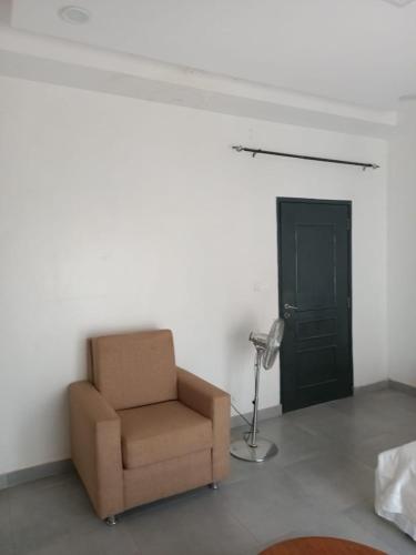 a room with a chair and a lamp and a door at Keur Dior Diagne in Thiès