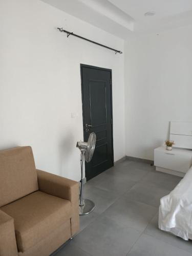 a living room with a chair and a black door at Keur Dior Diagne in Thiès