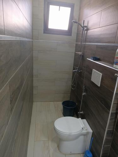 a small bathroom with a toilet and a window at Keur Dior Diagne in Thiès