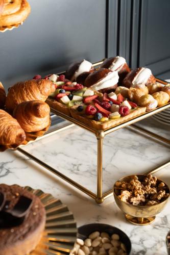 a tray filled with different types of pastries and bread at The Goethe Hotel - Small Luxury Hotels of the World in Rome