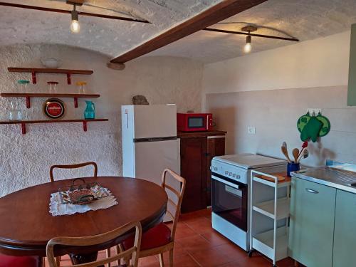 a kitchen with a table and a white refrigerator at La Gemma Netro in Netro