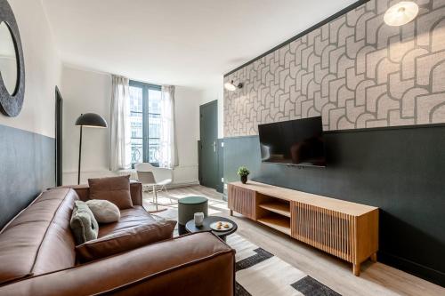 un salon avec un canapé et une télévision à écran plat dans l'établissement 42#Opera #Louvre #Paris02 #2bedrooms #AC, à Paris