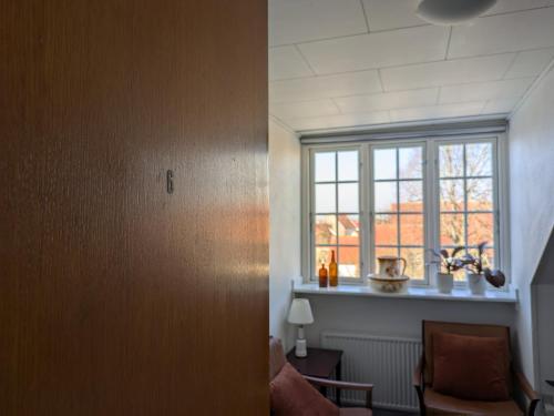 a living room with a window and a chair at Restaurant Backhaus in Ribe