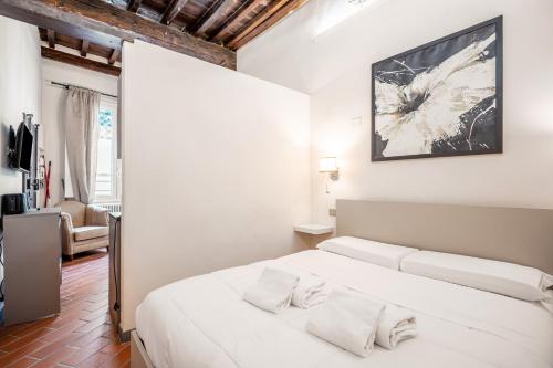 sypialnia z białym łóżkiem z 2 poduszkami w obiekcie Ponte Vecchio Central Flats we Florencji