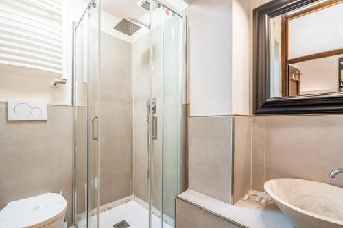 łazienka z przeszkloną kabiną prysznicową i umywalką w obiekcie Ponte Vecchio Central Flats we Florencji