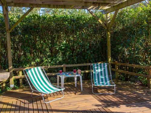deux chaises et une table sur une terrasse en bois dans l'établissement Holiday Home La Bruyère by Interhome, à La Bernerie-en-Retz