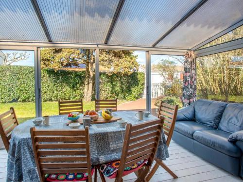eine Terrasse mit einem Tisch, Stühlen und einem Sofa in der Unterkunft Holiday Home La Bruyère by Interhome in La Bernerie-en-Retz