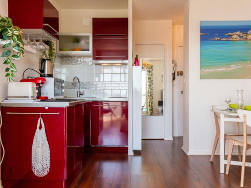 une cuisine avec des placards rouges et une salle à manger dans l'établissement Studio Océan by Interhome, à Seignosse