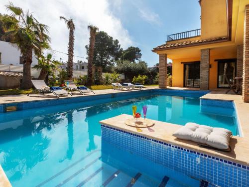 einen Pool mit einem Tisch und Stühlen neben einem Haus in der Unterkunft Villa Marea by Interhome in L'Ametlla de Mar