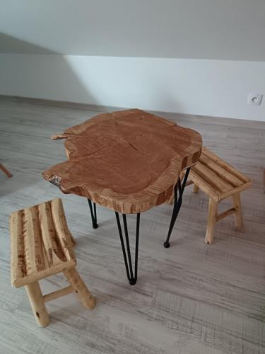 a wooden table and a bench in a room at Petit appartement à la campagne proche mer in Missillac