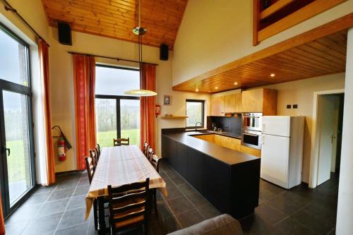 a kitchen with a table and a kitchen with a refrigerator at Gite Bouton d'Or in Heure