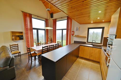 a kitchen and dining room with a table and a refrigerator at Gite Bouton d'Or in Heure