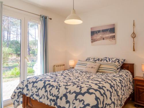 une chambre avec un lit et une grande fenêtre dans l'établissement Holiday Home Bosquet des Ecureuils 17 by Interhome, à Capbreton