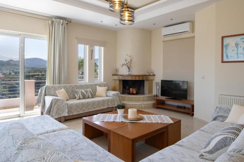 a living room with two couches and a tv at Villa Anatoli in Stalos