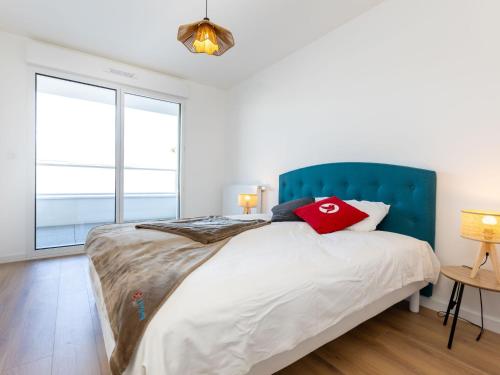 une chambre avec un grand lit avec une tête de lit bleue dans l'établissement Apartment Racines by Interhome, à Saint-Malo