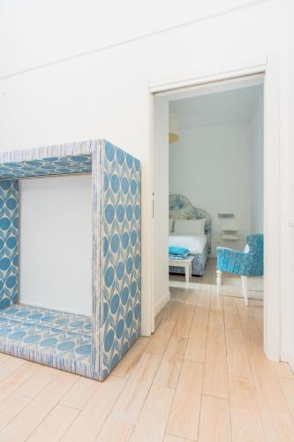 a living room with a mirror and a bed at Palazzo Gargiulo Luxury Rooms & Suites in Sorrento